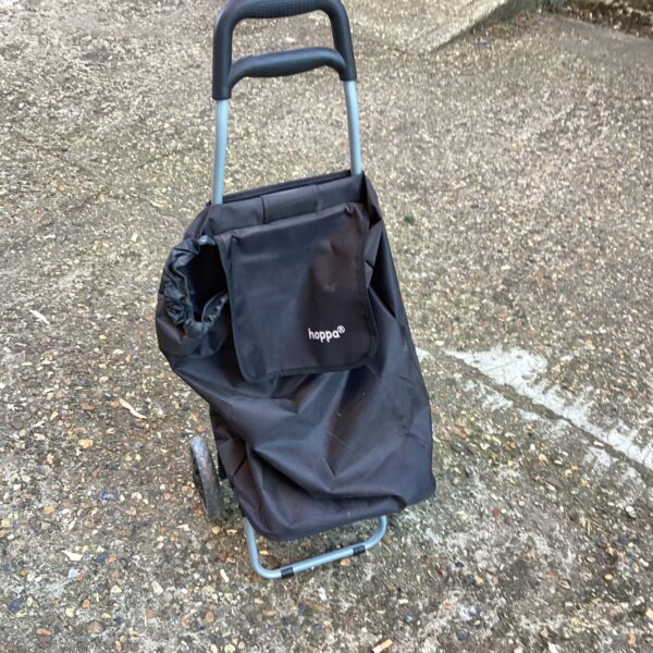 Blue Hoppa shopping trolley with wheels, folded for storage.