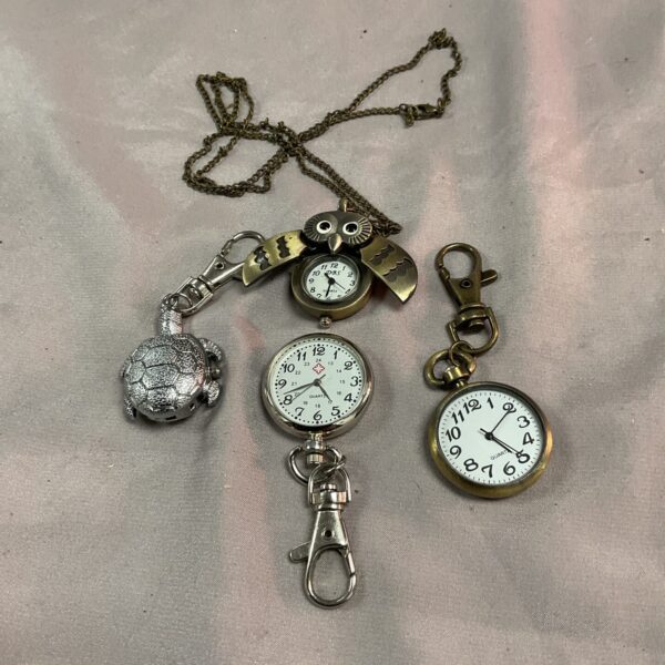 Vintage ladies pendant watches lot, close-up view of the miniature timepieces.
