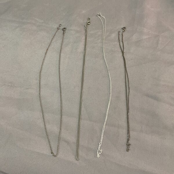 Four delicate silver necklaces presented as a lot.