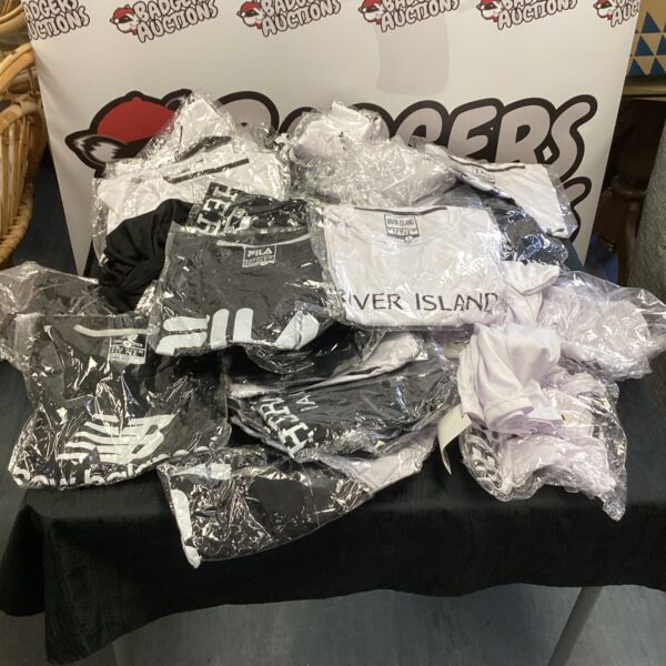Bulk lot of designer-style T-shirts for resale or retail.