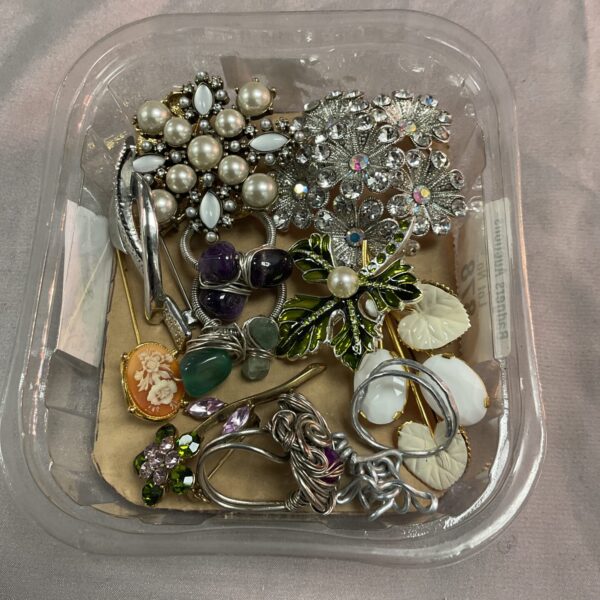 Vintage brooch and ring lot with floral and geometric designs.