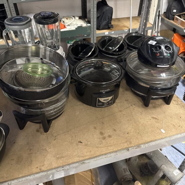 Halogen cookers and large Crock Pot in a kitchen appliance lot.