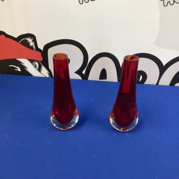 Pair of vibrant red Murano posey vases on a dark background.