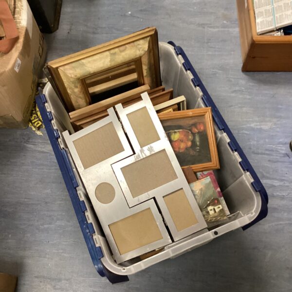 Assorted vintage picture frames in a plastic storage container.