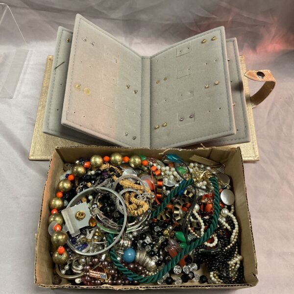 Costume jewellery lot with earring storage book displayed open.