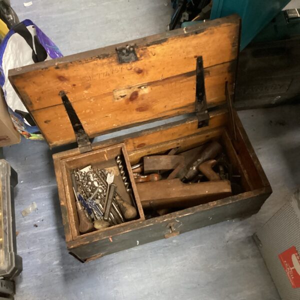 Vintage carpenters toolbox filled with antique woodworking tools.
