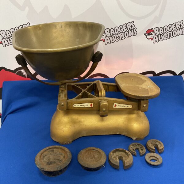 Vintage brass W & T Avery scales with weights for accurate measurement.