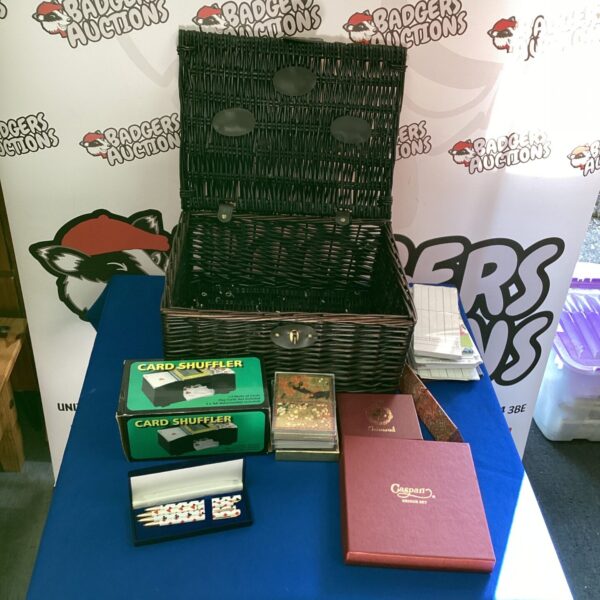 Wicker basket filled with a card games lot and card shuffler.