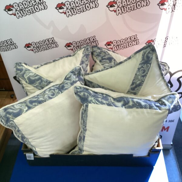 Set of five patterned sofa cushions displayed on a blue surface.