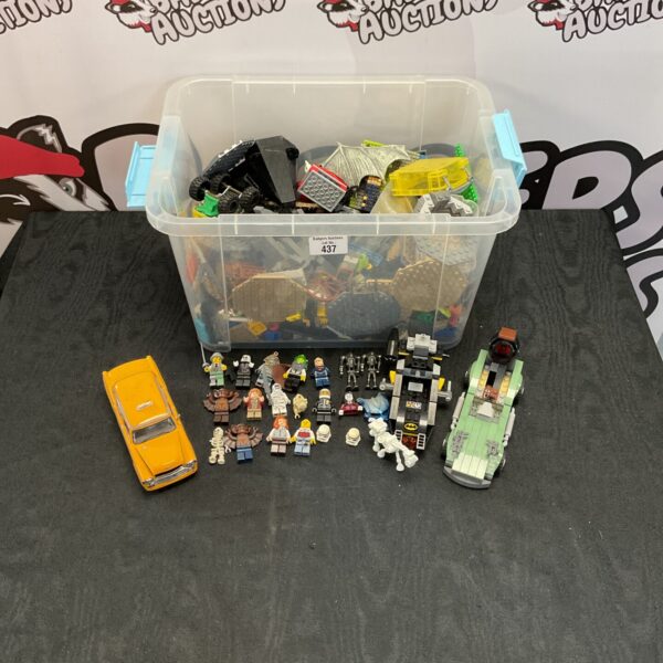 Large storage box filled with mixed Lego bricks and minifigures.