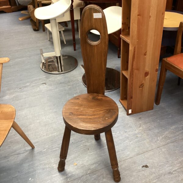 Reproduction spinning chair with a circular seat and back hole.