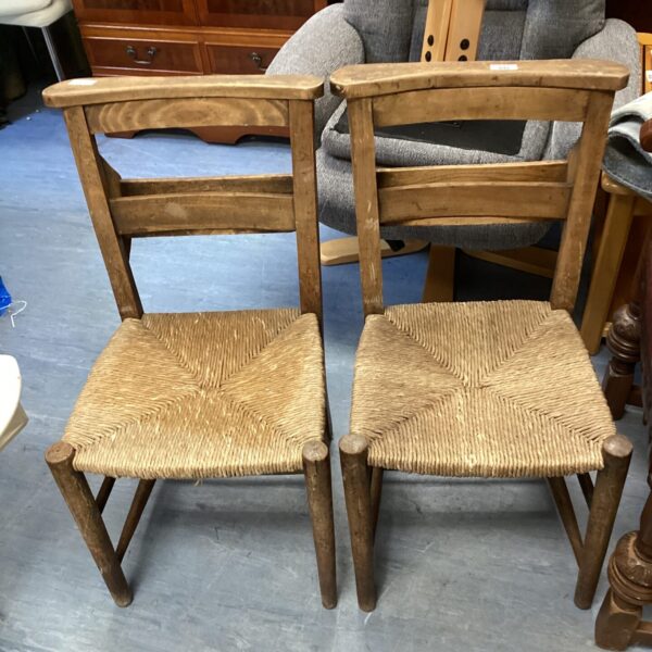 Pair of antique chapel chairs with woven seats.