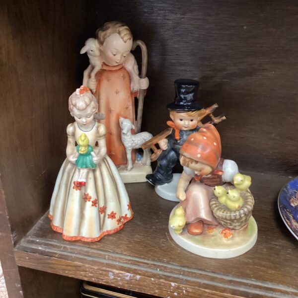 Group of four vintage Hummel and Goebel porcelain figurines.
