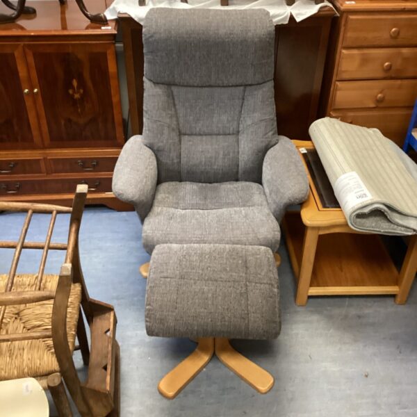Grey Dunelm recliner armchair with footstool in a living room.