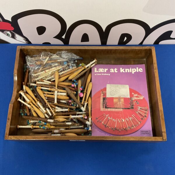 Antique lace bobbins collection with instructional book for lacemaking.