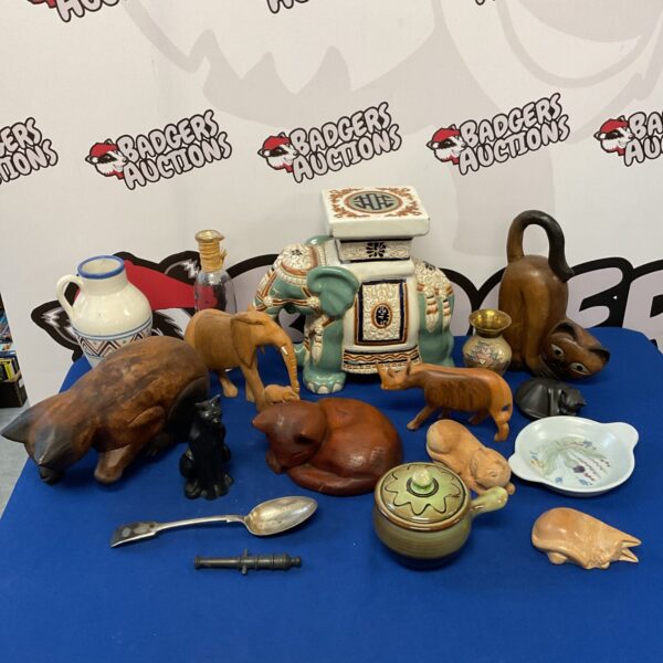 Collection of carved wooden cats, stone elephants, and a ceramic stand.