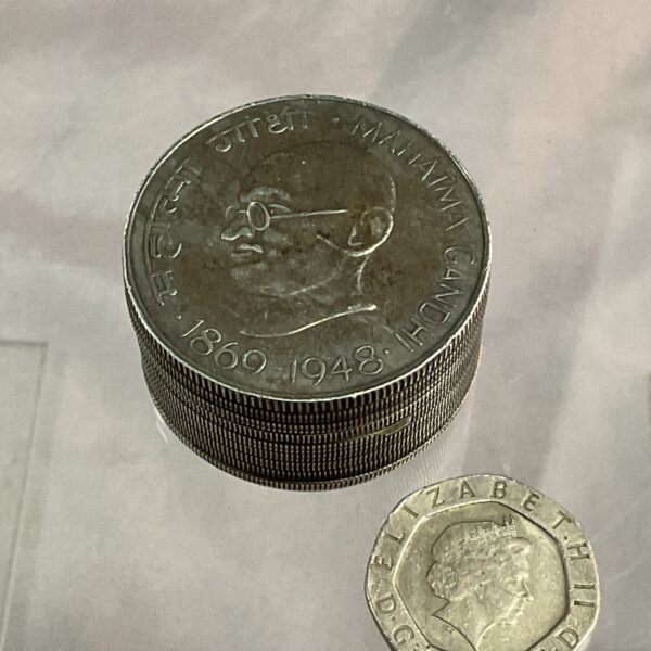 Stack of silver Gandhi coins forming a vintage trinket pot.