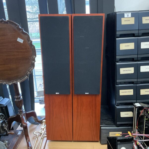 Pair of Bowers & Wilkins CM04 floorstanding speakers in a home setting.
