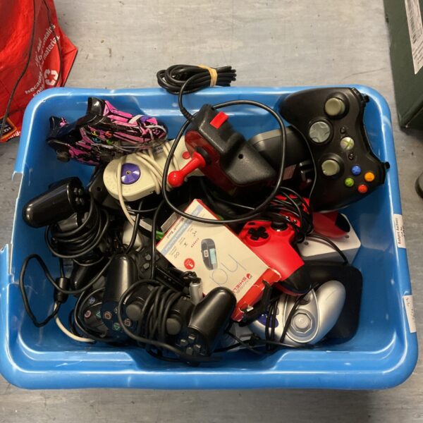 Lot of assorted vintage and modern gaming controllers and joysticks.