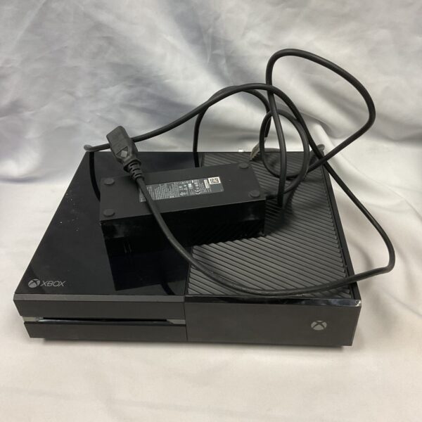 Black Xbox One console with power supply, front view.