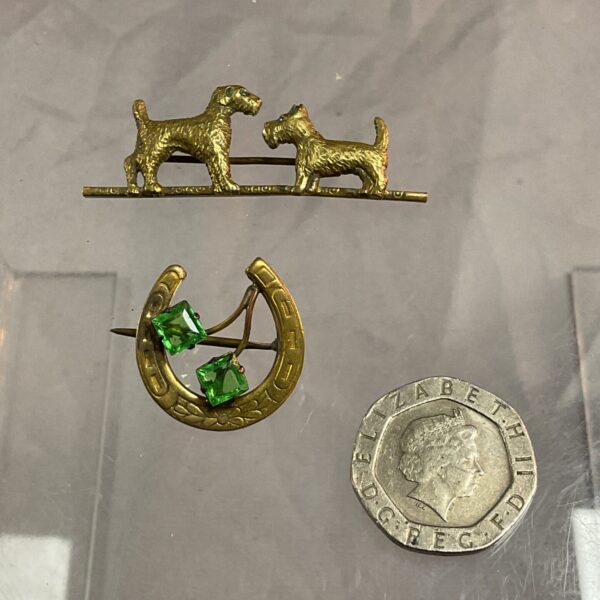Vintage horseshoe and dog brooch with green stones.