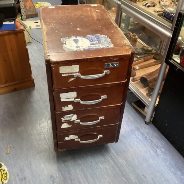 Vintage metal tool cabinet on wheels for workshop storage.