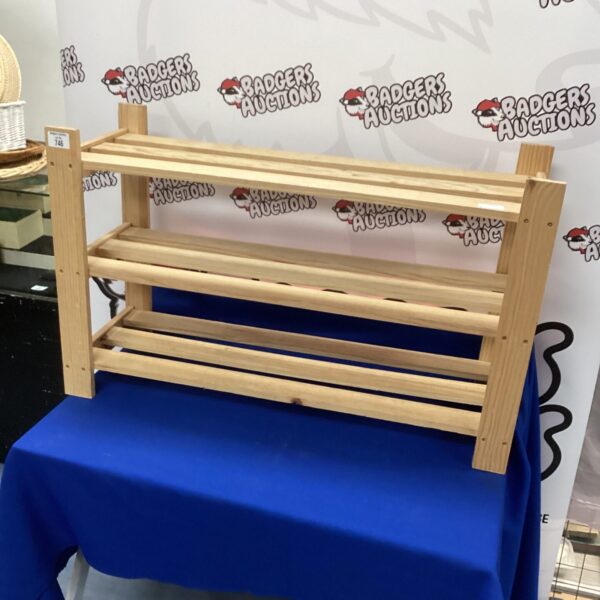Three-tiered pine shoe rack for hallway or bedroom storage.