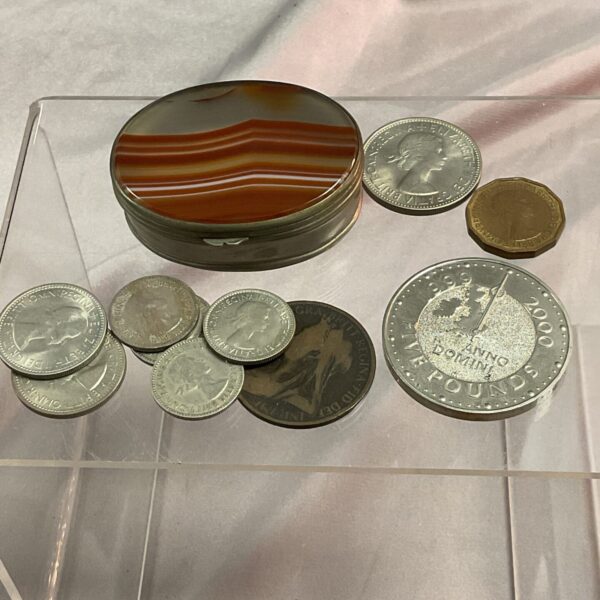 Vintage stone lidded trinket pot with assorted coins.