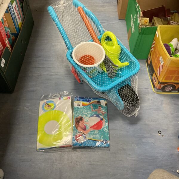 Bright blue childrens plastic wheelbarrow with garden tools and pool float.