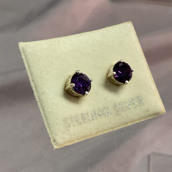 Close-up of sterling silver amethyst stud earrings.