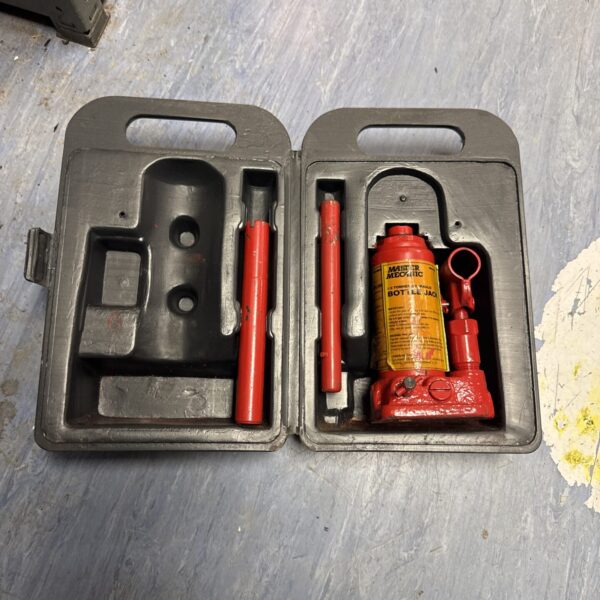 Red Master Mechanic 1.5 ton bottle jack in plastic case.