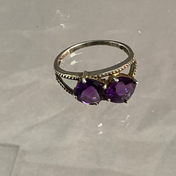 Silver ring with a vibrant purple amethyst gemstone.