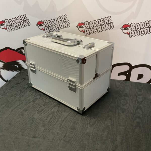 Closed silver aluminium cosmetic case on grey background.