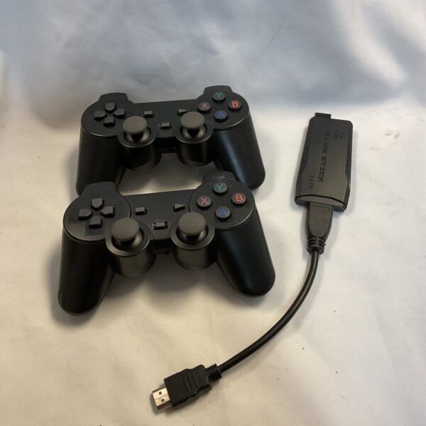 Black PlayStation 3 controllers and GameStick Lite 4K streaming device.