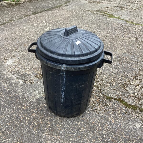 Black plastic dust bin with lid for garden or household waste.