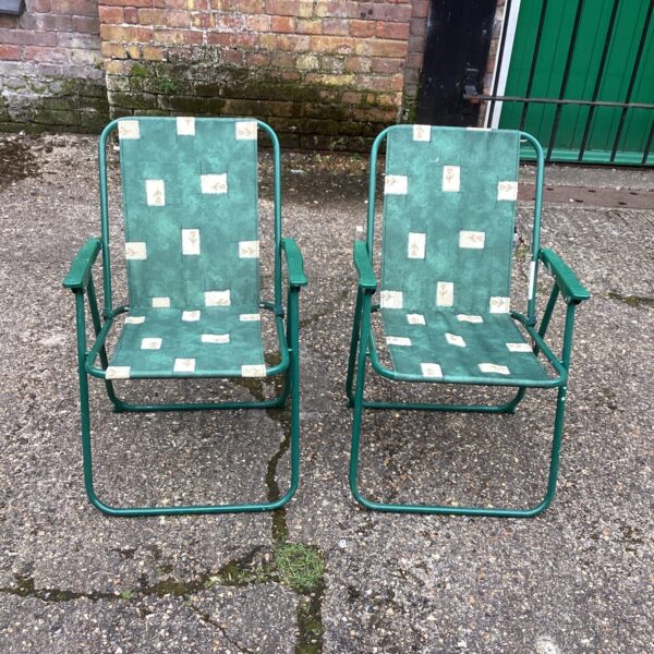 Pair of vintage folding garden chairs in a garden setting.