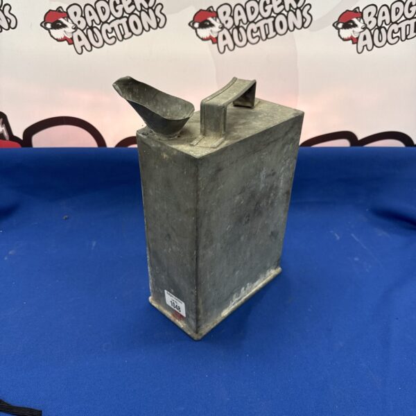 Vintage metal oil can with visible wear and tear.