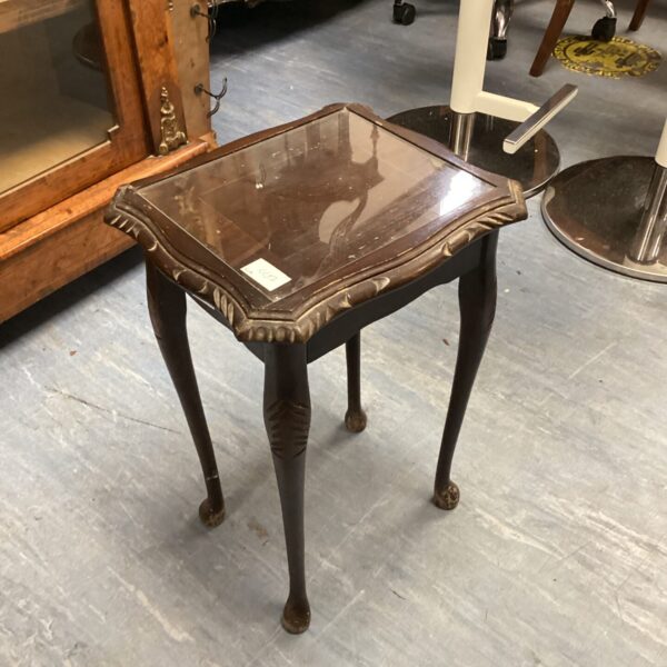 Antique mahogany side table with glass top and curved legs.