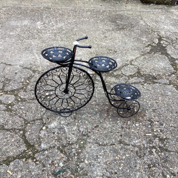Vintage Penny Farthing plant stand with tiered platforms for displaying plants.
