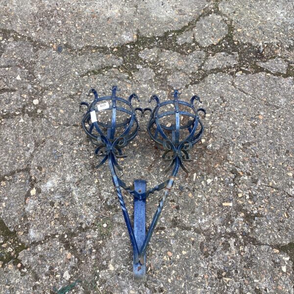 Vintage wrought iron wall mounted plant holder for garden display.
