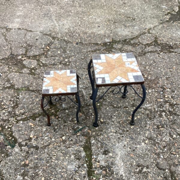 Vintage wrought iron flower pot stands with mosaic tile tops.