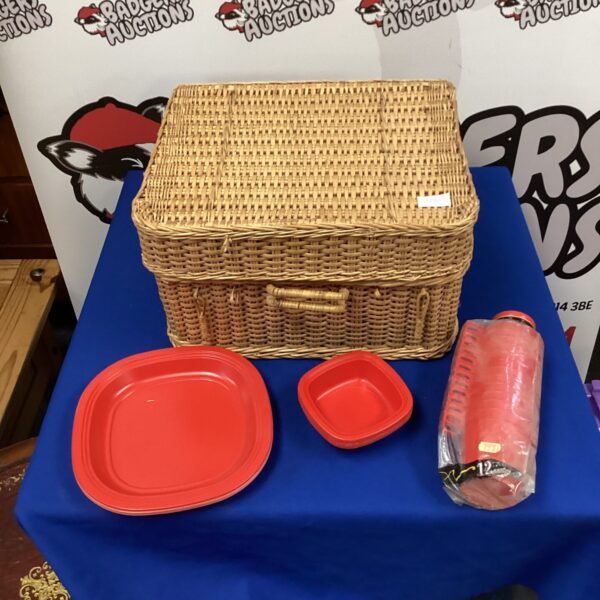 Vintage wicker picnic basket with plates and dining set.