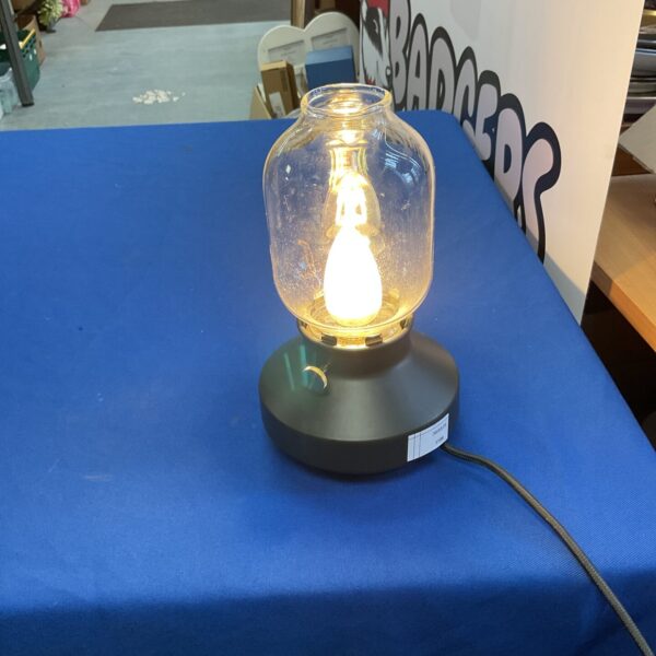 Modern Ikea table lamp with clear glass shade and black base.