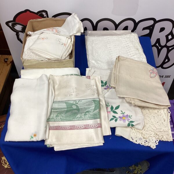 Vintage linen tablecloths in a mixed lot, showcasing embroidery and lace.