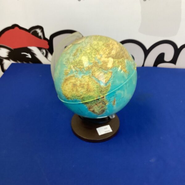 Vintage illuminating globe on wooden base, detailed geographic markings.