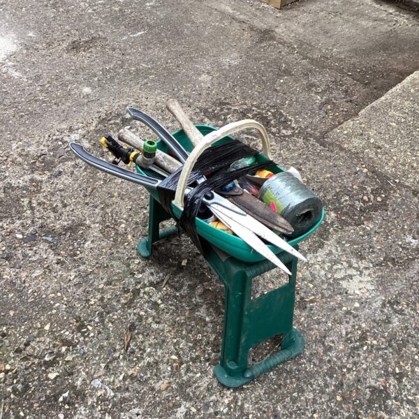 Green garden tool set with kneeler and various hand tools.