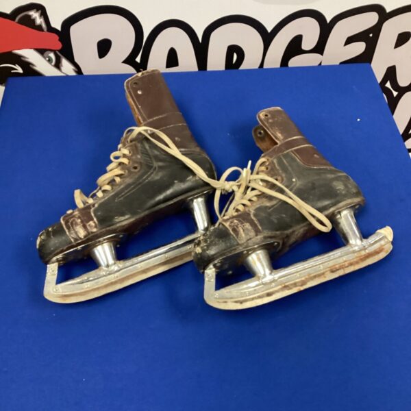 Pair of vintage leather ice skates with metal blades.