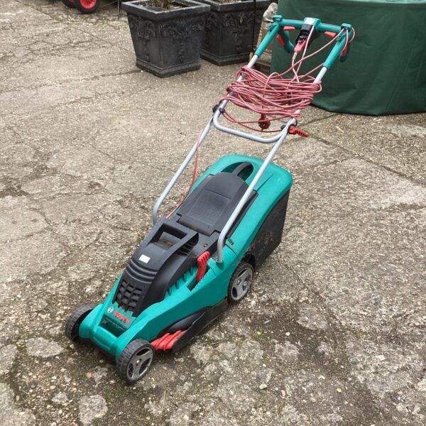 Green Bosch electric lawn mower in used condition.