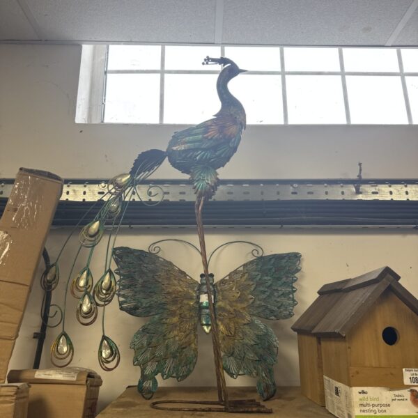 Large metal peacock and butterfly garden ornaments for outdoor display.