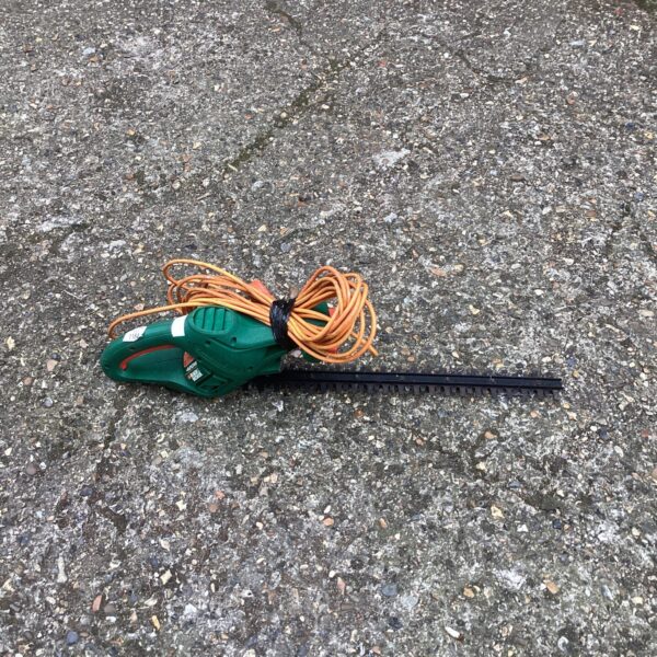 Black and Decker electric hedge cutter for garden trimming and landscaping.